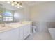 Elegant bathroom with double vanity, soaking tub, and walk-in shower at 8896 Dove Cove Dr, Las Vegas, NV 89129