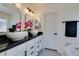 Modern bathroom with double sinks, white cabinets, and a soaking tub at 9279 Cabin Cove Ave, Las Vegas, NV 89148