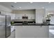 Modern kitchen with white cabinets, black countertops, stainless steel appliances and breakfast bar at 9279 Cabin Cove Ave, Las Vegas, NV 89148