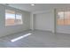 Bright living room with grey wood-look floors and large windows at 9279 Cabin Cove Ave, Las Vegas, NV 89148