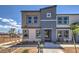 Two-story townhome with gray and beige exterior, landscaping, and a bench at 9315 Jade Mesa St # Lot 62, Las Vegas, NV 89139