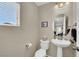 Small half bathroom with pedestal sink and updated fixtures at 9916 Fallowdeer Ct, Las Vegas, NV 89149