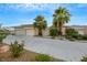 Tan two-story house with two palm trees and a long driveway at 10275 Tresor Ct, Las Vegas, NV 89135