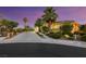 Stunning curb appeal at dusk with palm trees and landscaping at 10275 Tresor Ct, Las Vegas, NV 89135