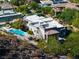 Aerial shot of an amazing home featuring lush green trees, an in-ground pool, and manicured landscaping at 1635 Liege Dr, Henderson, NV 89012