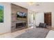 Cozy bedroom featuring a modern fireplace, TV, and a large window overlooking the yard, creating a cozy retreat at 1635 Liege Dr, Henderson, NV 89012