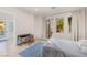 Bright bedroom featuring neutral walls, tile floors, double doors to the outside, and a built-in desk area at 1635 Liege Dr, Henderson, NV 89012