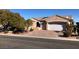 Tan house with a three-car garage and mature trees at 1736 Williamsport St, Henderson, NV 89052