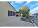 Landscaped backyard with gravel, mature trees, and a partial view of a pool at 2080 Twin Falls Dr, Henderson, NV 89044