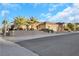 Single-story house with tan exterior, three-car garage, and palm trees at 2080 Twin Falls Dr, Henderson, NV 89044