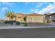 Tan house with tile roof, three-car garage, and lush landscaping at 2080 Twin Falls Dr, Henderson, NV 89044