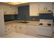 Kitchen with white cabinets, blue walls and wood floors at 2616 Aracatuba Ave, Las Vegas, NV 89121