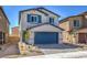 Two-story house with gray siding, blue garage door, and landscaped front yard at 2642 Snapdragon Falls Ave # 93, North Las Vegas, NV 89081