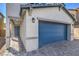 Two-car garage with gray siding, blue door and walkway to entry at 2642 Snapdragon Falls Ave # 93, North Las Vegas, NV 89081