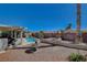 Landscaped backyard with a firepit and a view of the pool and patio at 2715 Coral Cliffs Ct, North Las Vegas, NV 89031