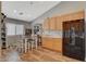 Eat-in kitchen with wood floors and black fridge at 2715 Coral Cliffs Ct, North Las Vegas, NV 89031