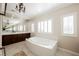 Elegant bathroom with soaking tub, double vanity, and large windows at 2768 Liberation Dr, Henderson, NV 89044