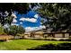 Landscaped front yard with lush green grass, mature trees, and beautiful community homes at 2768 Liberation Dr, Henderson, NV 89044