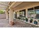 View of covered back patio with brick flooring, windows, and potted plants at 3363 Blue Ribbon Downs St, Las Vegas, NV 89122