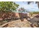 Garden beds line a charming brick walkway leading to the backyard wall at 3363 Blue Ribbon Downs St, Las Vegas, NV 89122