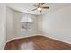 Bright bedroom featuring hardwood floors, a ceiling fan, and a large window at 3363 Blue Ribbon Downs St, Las Vegas, NV 89122