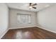 Bright bedroom with hardwood floors, ceiling fan, and window with blinds, creating a serene atmosphere at 3363 Blue Ribbon Downs St, Las Vegas, NV 89122