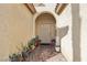 Entrance to a home featuring desert landscaping in pots leading to an arched doorway at 3363 Blue Ribbon Downs St, Las Vegas, NV 89122