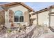 Close-up of the front of a single-story home featuring desert landscaping and shutters at 3363 Blue Ribbon Downs St, Las Vegas, NV 89122