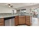 Granite countertops, stainless steel dishwasher, wood cabinets, and tile floors highlight this kitchen space at 3363 Blue Ribbon Downs St, Las Vegas, NV 89122