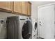 Laundry room features a front loading washer and dryer with overhead wood cabinets at 3363 Blue Ribbon Downs St, Las Vegas, NV 89122