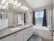 Elegant bathroom with double sinks, soaking tub, and gray counters at 414 Maritocca Ave, North Las Vegas, NV 89031