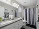 The bathroom has double sinks, a toilet, and a shower with a black and white striped curtain at 414 Maritocca Ave, North Las Vegas, NV 89031