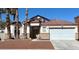 Inviting single-story home boasts well-kept landscaping, a two-car garage, and a classic, neutral-toned stucco exterior at 414 Maritocca Ave, North Las Vegas, NV 89031