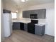 Galley kitchen with gray cabinets, black appliances, and tile flooring at 4522 Checker Way, North Las Vegas, NV 89031