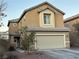 Two-story house with beige exterior, attached garage, and landscaping at 5066 El Castano Ave, Las Vegas, NV 89108