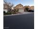 Two-story house with beige exterior, attached garage, and landscaping at 5066 El Castano Ave, Las Vegas, NV 89108