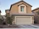 Tan two-story house with a beige garage door and landscaping at 5066 El Castano Ave, Las Vegas, NV 89108