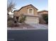 Two-story house with beige exterior, attached garage, and landscaping at 5066 El Castano Ave, Las Vegas, NV 89108