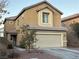 Two-story house with attached garage, landscaping, and a circular window at 5066 El Castano Ave, Las Vegas, NV 89108