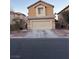 Tan two-story house with a beige garage door and landscaping at 5066 El Castano Ave, Las Vegas, NV 89108