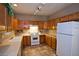 Wood cabinets, tile floor, and white appliances in kitchen at 5066 El Castano Ave, Las Vegas, NV 89108