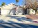 Single-story house with a two-car garage and landscaped yard at 6256 Hill Haven Ave, Las Vegas, NV 89130