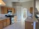 Kitchen with light wood cabinets, stainless steel appliances and tile floor at 6256 Hill Haven Ave, Las Vegas, NV 89130