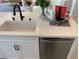 Modern kitchen island with white cabinets, quartz countertops, and a stainless steel dishwasher at 630 Moonbeam Way, Mesquite, NV 89027