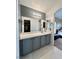 Bathroom with a large mirror above the gray vanity and dual sinks, with closet visible through door at 6449 Stone Dry Ave # 101, Henderson, NV 89011