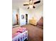 Bedroom with brown carpet, wood dresser, ceiling fan, and pink and brown decorative wall design at 6449 Stone Dry Ave # 101, Henderson, NV 89011