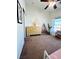 Bright bedroom with brown carpet, wood dresser, ceiling fan, and pink and brown decorative wall at 6449 Stone Dry Ave # 101, Henderson, NV 89011