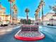 Boulder Ranch entrance featuring mature palm trees, landscaping, and clear blue skies in a well-maintained community at 6449 Stone Dry Ave # 101, Henderson, NV 89011