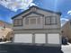 Three car garage exterior of home with gray paint and a window on the second story at 6449 Stone Dry Ave # 101, Henderson, NV 89011