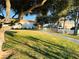 View of a large grassy common area among two-story buildings with sidewalks, trees, and white fencing at 6449 Stone Dry Ave # 101, Henderson, NV 89011